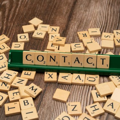 the word contact is spelled out with wooden letters